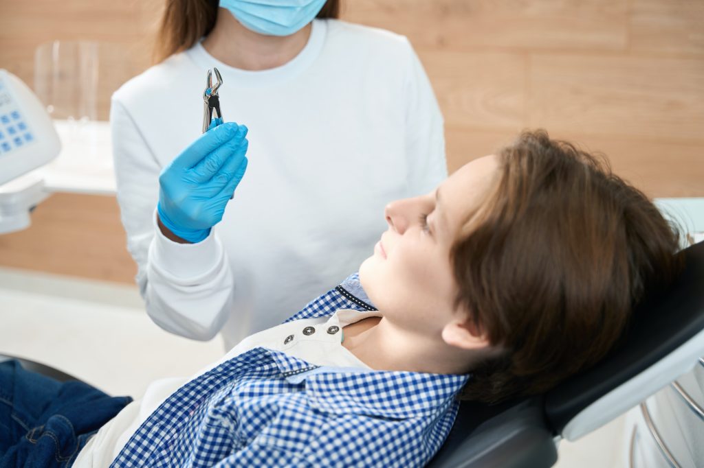 Boy looks at a special tool for tooth extraction